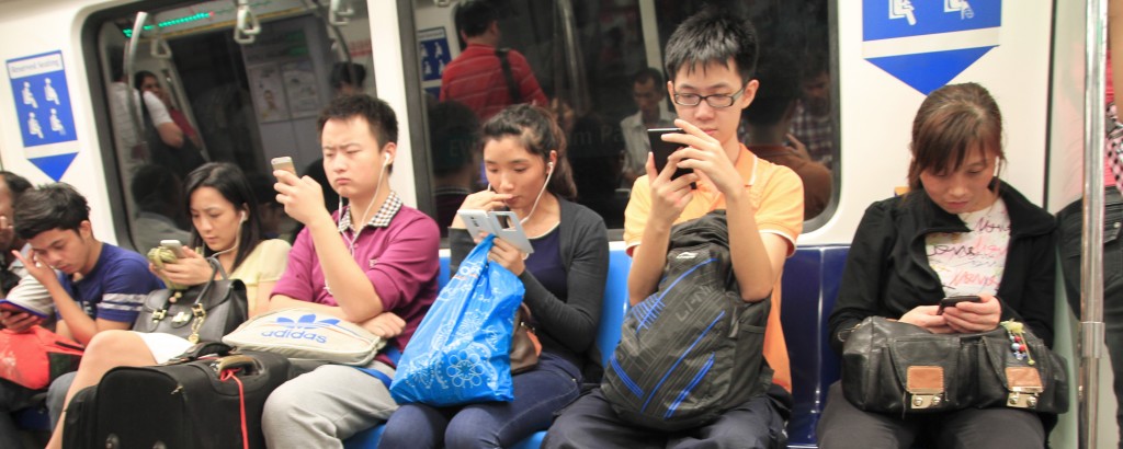 Passageiros de um metro olhando para seus celulares