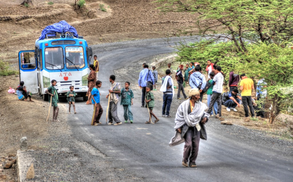 ônibus encostado na estrada na Etiópia com o pneu furado