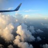 Da janela de um avião, a vista para as nuvens e o mar ao entardecer